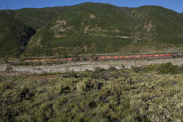 BNSF 7731 [GE ES44DC] rolls down hill from Cajon pass to Barstow leading a long westbound stack train at Bluecut Canyon, CA. on Subday 30-May-10