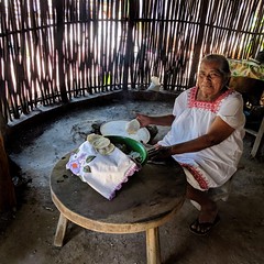 Making tortillas by hand in a traditional Mayan hut