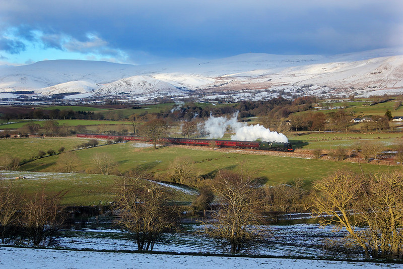 Clad with snow, the summits from left to right, of Cross Fell, Little Dun Fell and Great Dun Fell make up the impressive backdrop for No.46233 'Duchess of Sutherland' making her way past Keld.