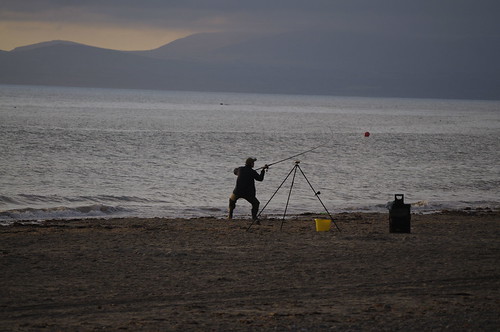 Morfa Dyffryn Beach, Wales Fisherman casting nr Shell Island beach Wales