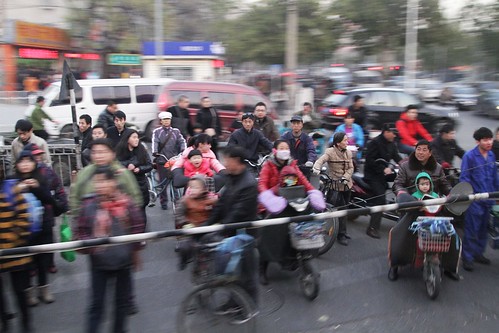 Cyclists and pedestrians waiting on Xueyuan South Road in Haidian District for our train to clear the level crossing