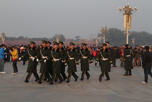 PLA soldiers march past for the start of the flag lowering ceremony