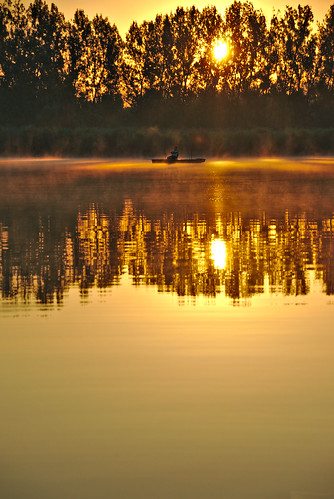 orange man reflection reed water sunrise boat angler