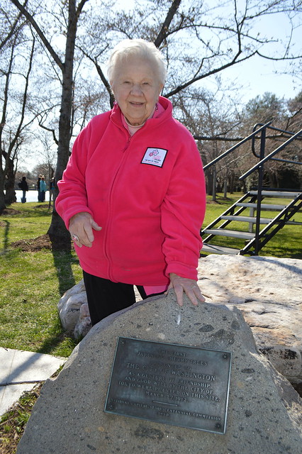 Theresa Irene Wolowski at the bronze plaque commemorating the two original cherry blossom trees planted by First Lady Helen Herron Taft and Viscountess Chinda on March 27, 1912 at The Tidal Basin in Washington, D.C. USA