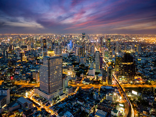 Aerial view of Bangkok skyline and skyscraper with BTS skytrain Bangkok downtown. Panorama of Sathorn and Silom business district Bangkok Thailand at night.