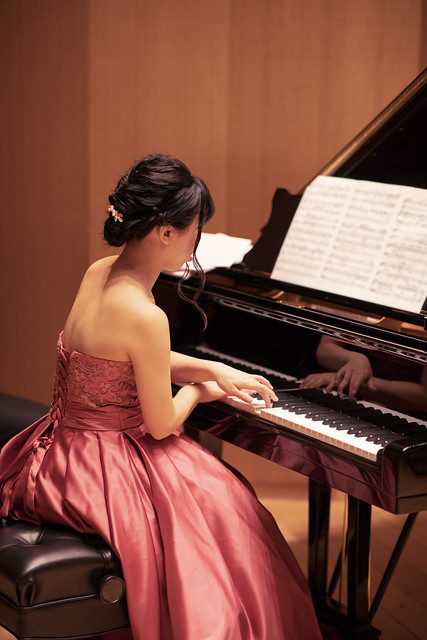 Beautiful woman playing piano in concert
