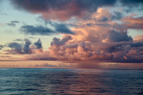 Sunset off the Cook Islands by adamsgc1, and a rain cloudsunset cookislands clouds rain raincloud cunardline queenelizabeth ocean