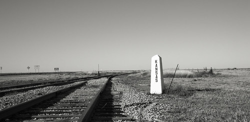 railroadtracks horizon marker shadows shortgrassprairie fence signs monochrome vanishingpoint blackandwhite weathered pylon
