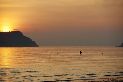thailand bay thai beach seaside resort rural town village tourism tourist morning early trees peaceful quiet empty deserted ocean waves sunrise goldenhour silhouette backlight woman swimming wading people