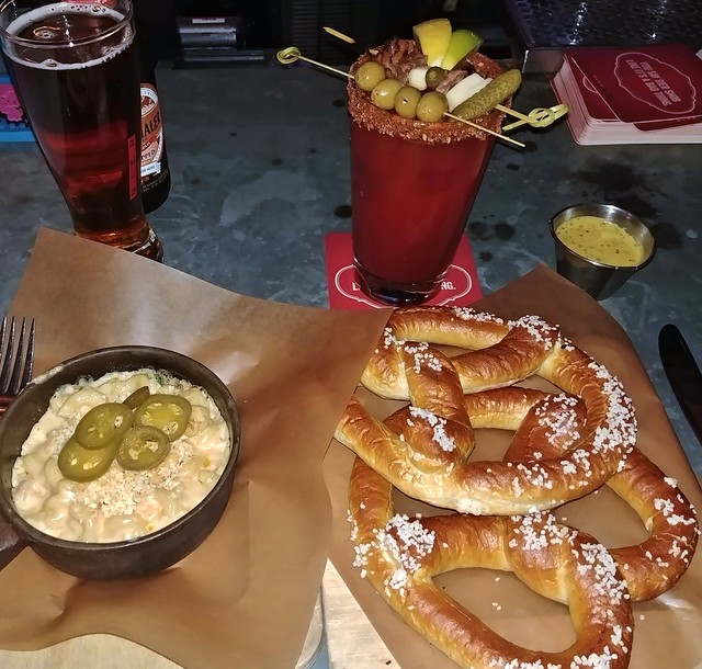 Bacon and jalapeno macaroni and cheese; two warm soft salty fluffy pretzels with grainy beer mustard; Clausthaler Dry-Hopped Amber Lager; Charcuterie Caesar with olives, pickles, bacon, sausage and cheese