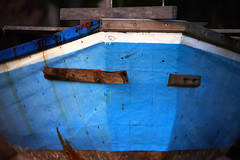 Bow of a blue fishing boat on the beach