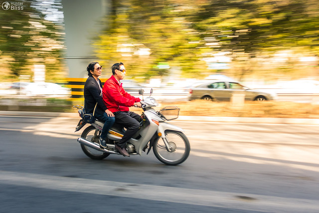 Chinese People Riding a Motorcycle on the street
