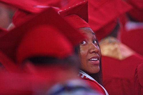 Graduate looks back over her shoulder in search of family in the crowd.