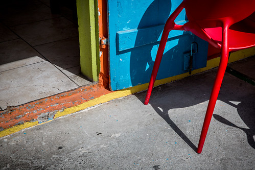 floor door chair red blue concrete vivid sun shadow highcontrast entrance restaurant